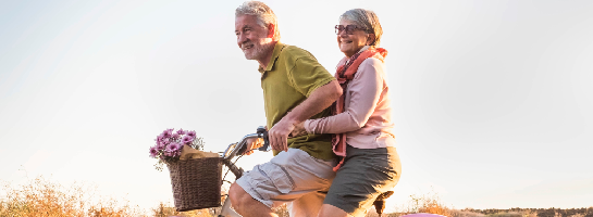 Ouder echtpaar wat samen op de fiets van de laatste zonnestralen geniet.