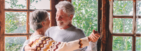 Een stel dat lachend met elkaar danst.